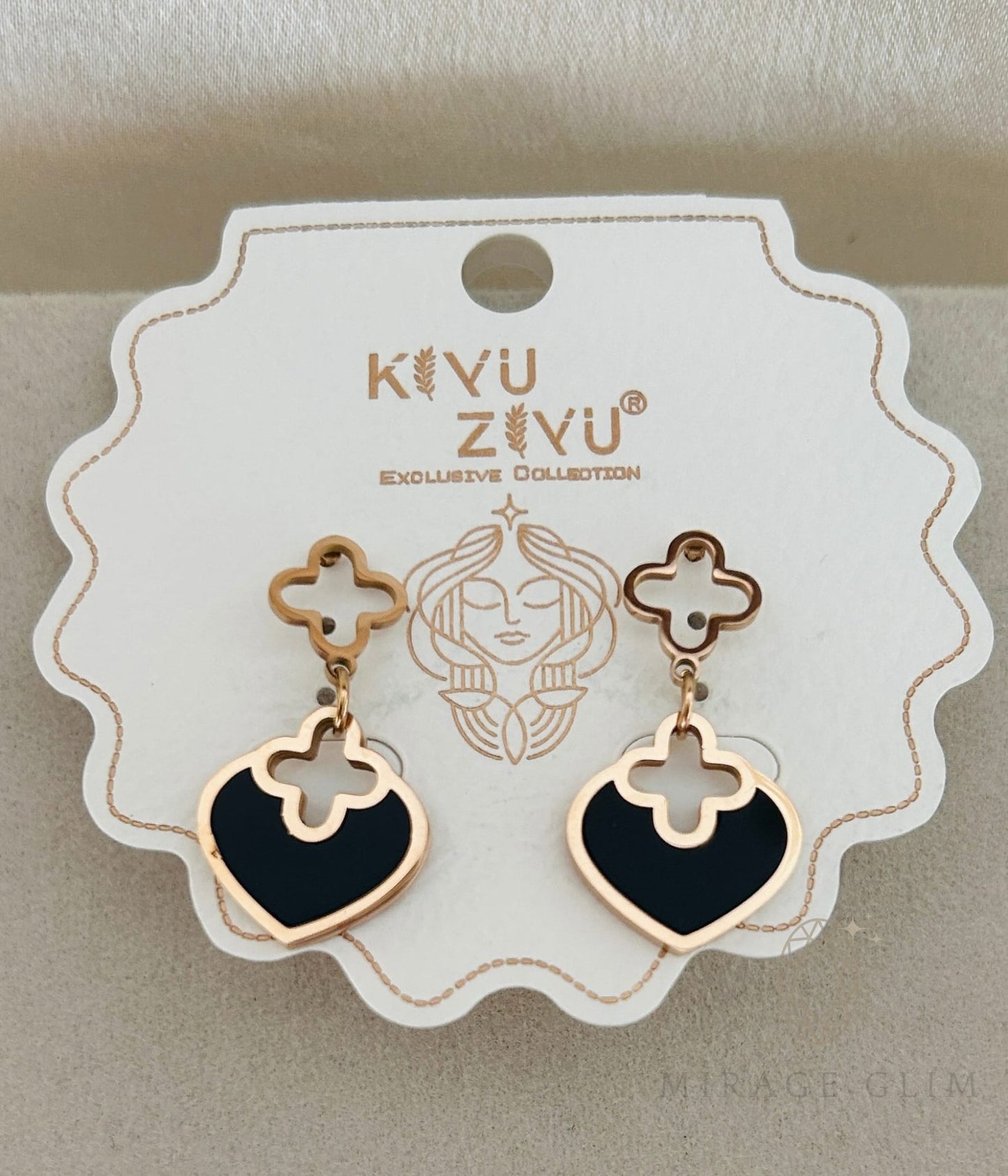 Black heart earrings with gold clover accents in refined style