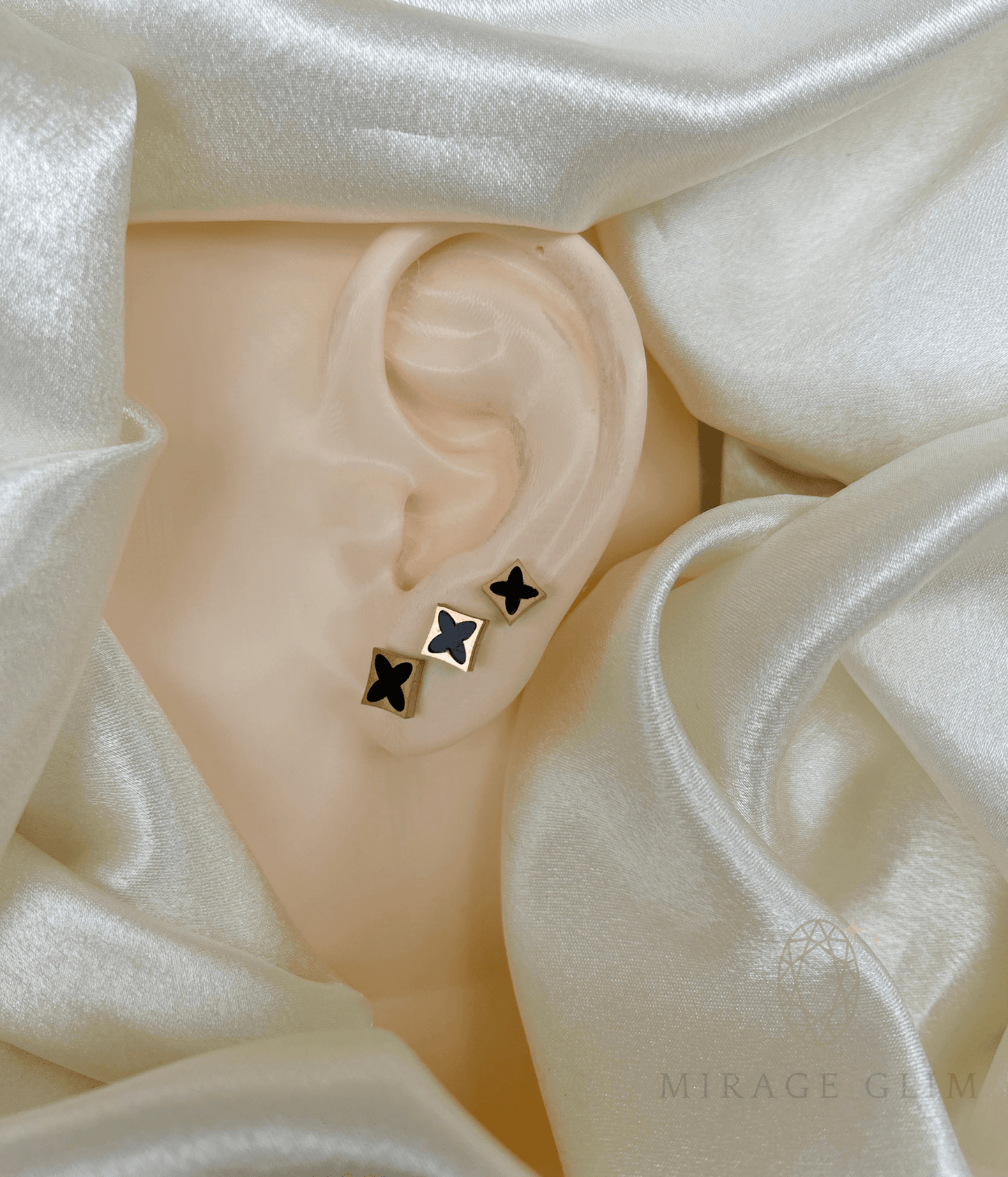 Minimal star stud earrings arranged along the ear
