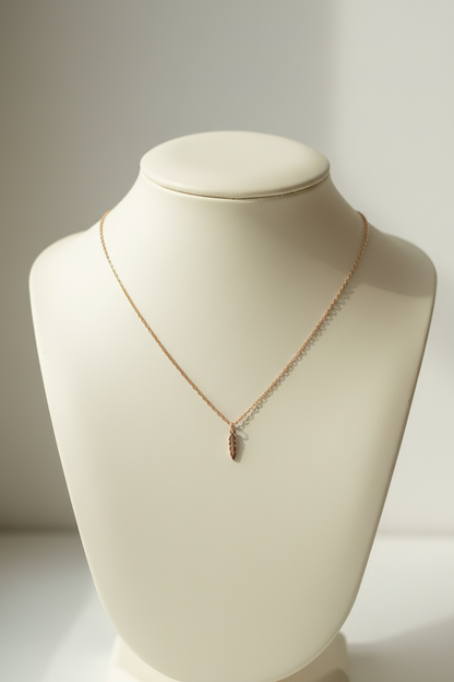 Rose Gold necklace on a textured gray surface