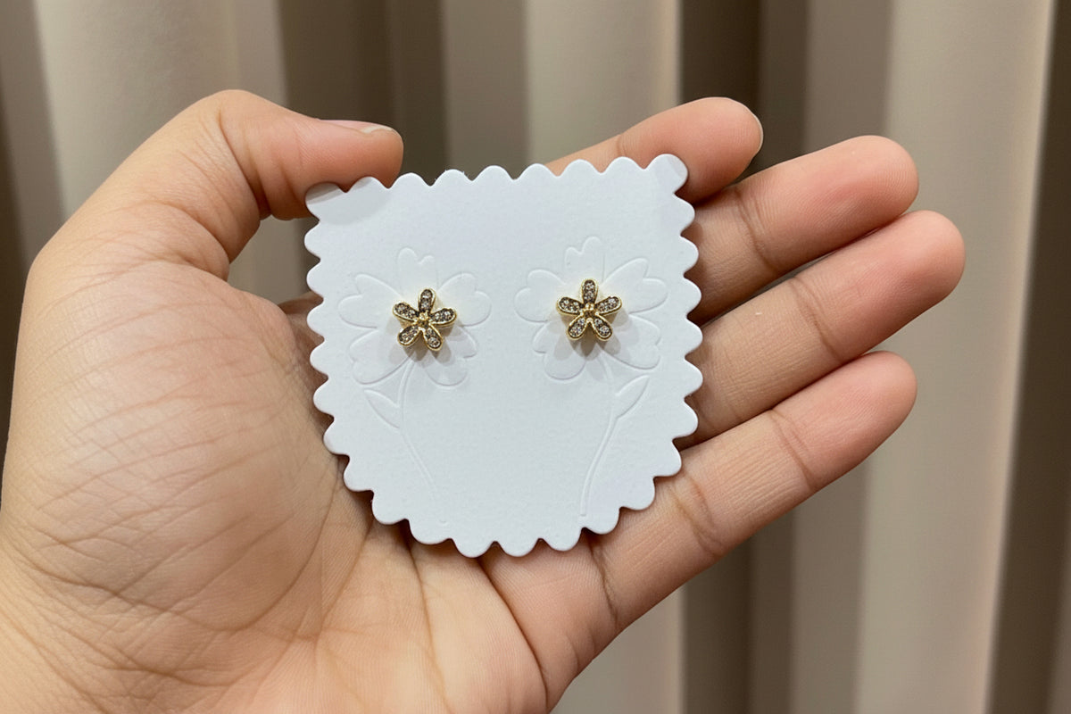 Gold-tone CZ crystal flower stud earrings on display card