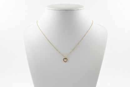 Gold necklace on a textured gray surface