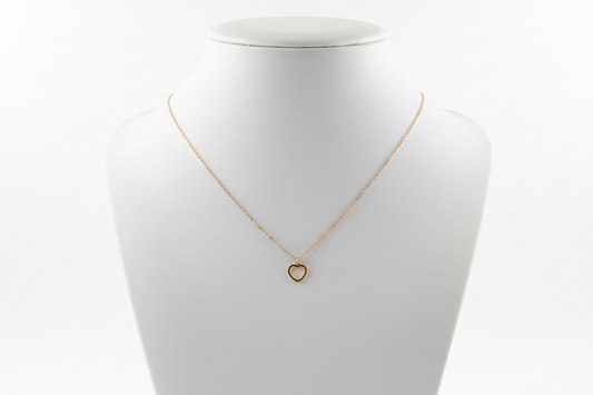 Gold necklace on a textured gray surface