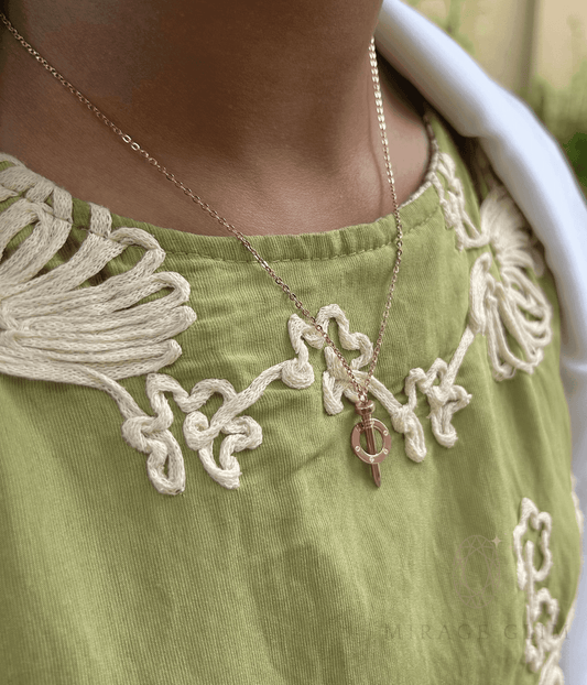 Minimal nail-inspired pendant necklace worn on collarbone