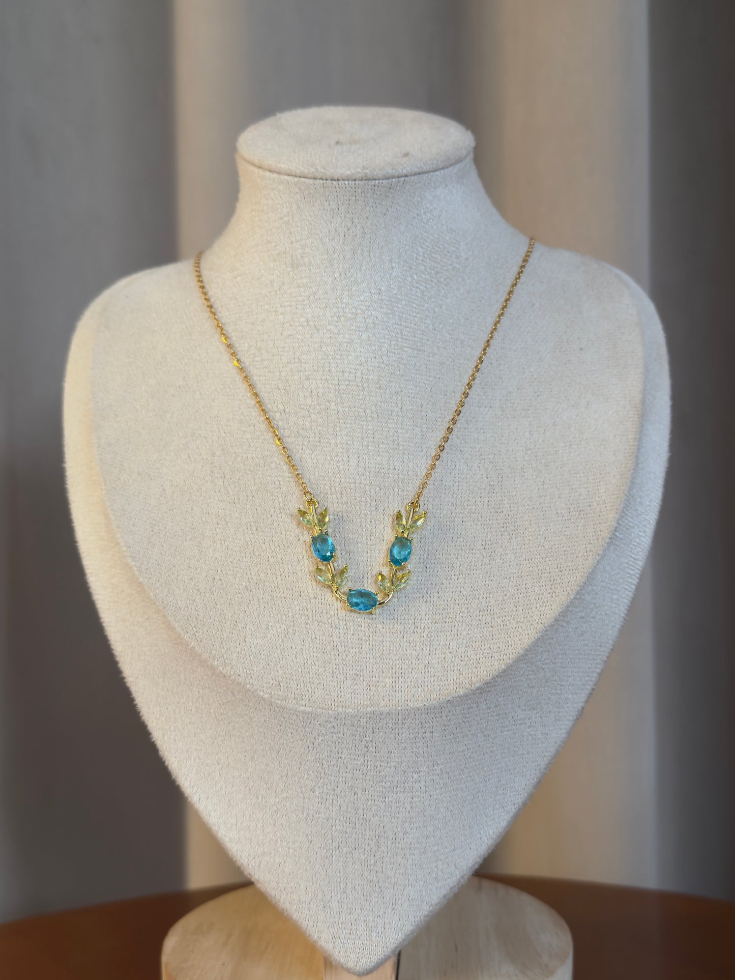 Gold anti-tarnish tulip necklace featuring sparkling blue tulip-shaped crystal accents on a delicate chain