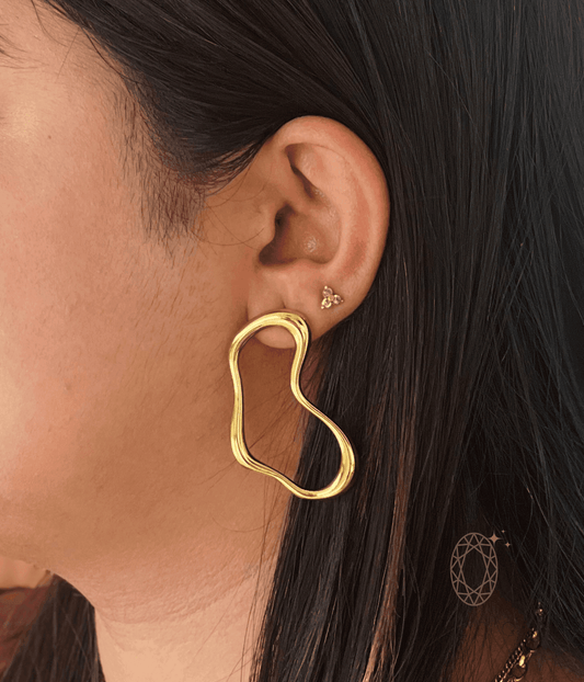sculptural bold twist earrings with fluid organic curves worn on ear