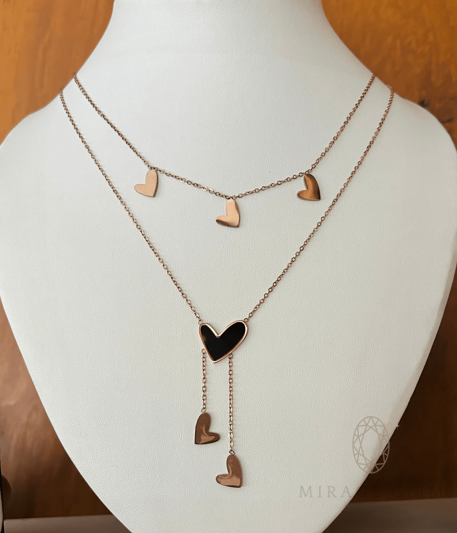 Layered heart necklace with delicate gold heart charms on display bust