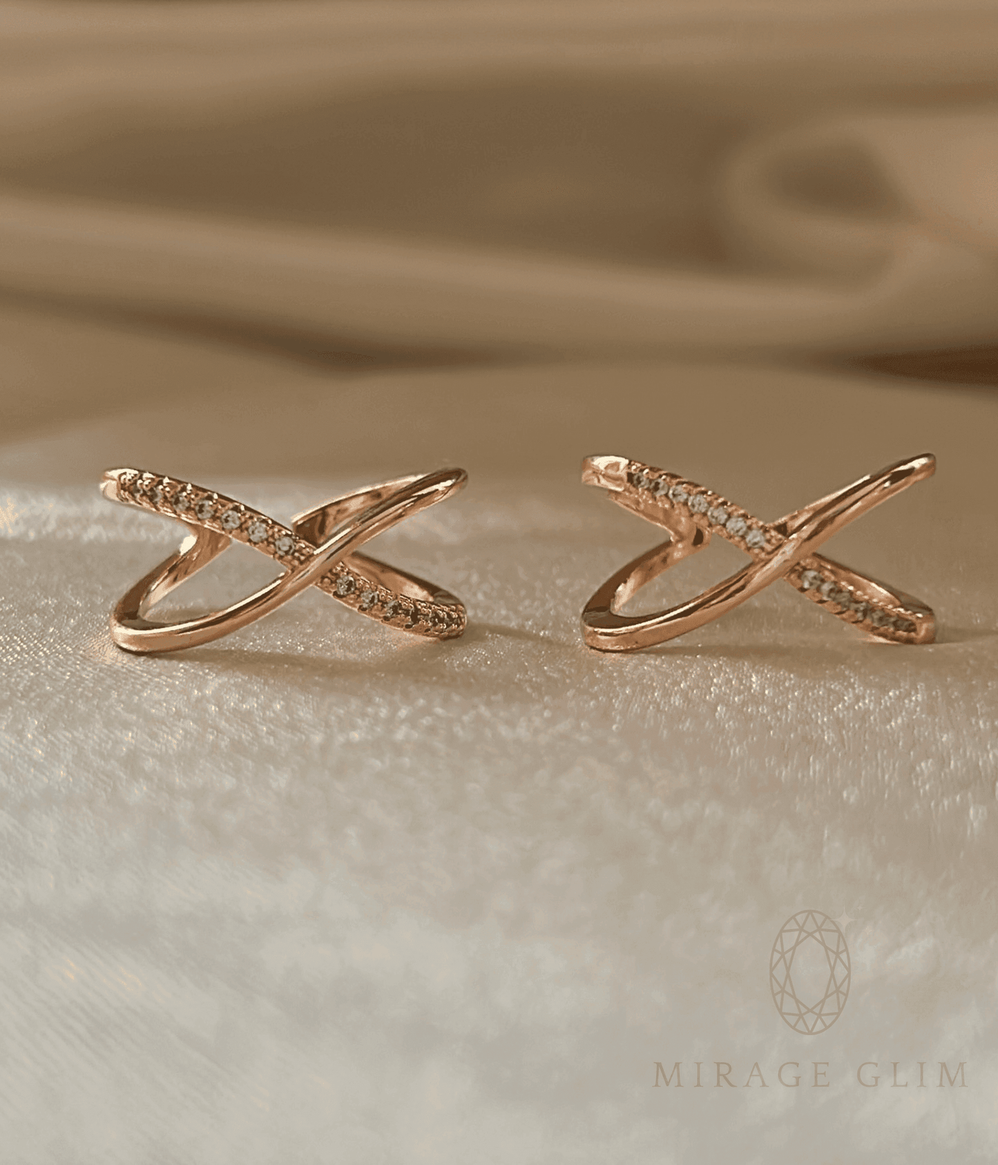 Evara crossed pavé ring on a beige fabric background