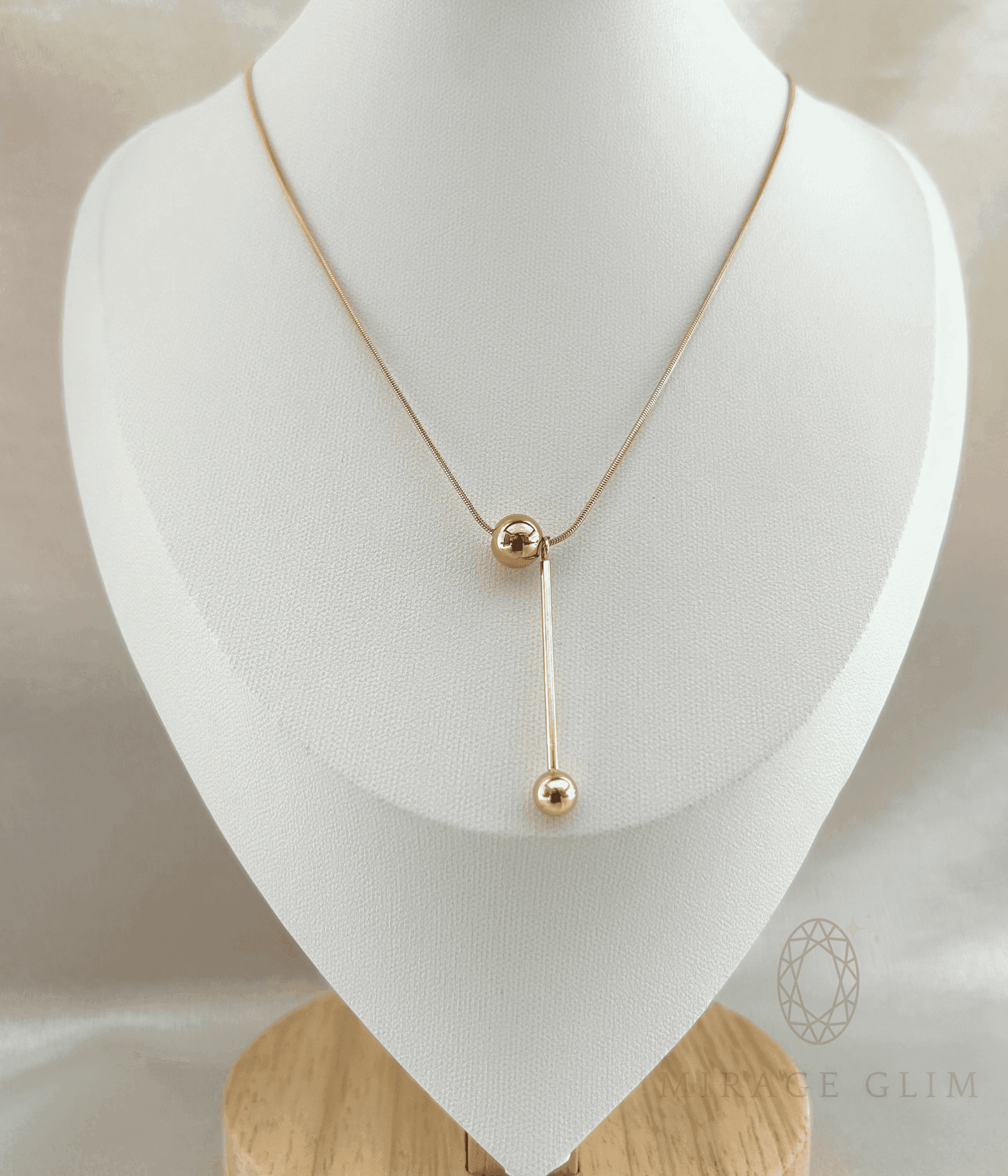 Elegant drop necklace with elongated vertical design on jewelry bust