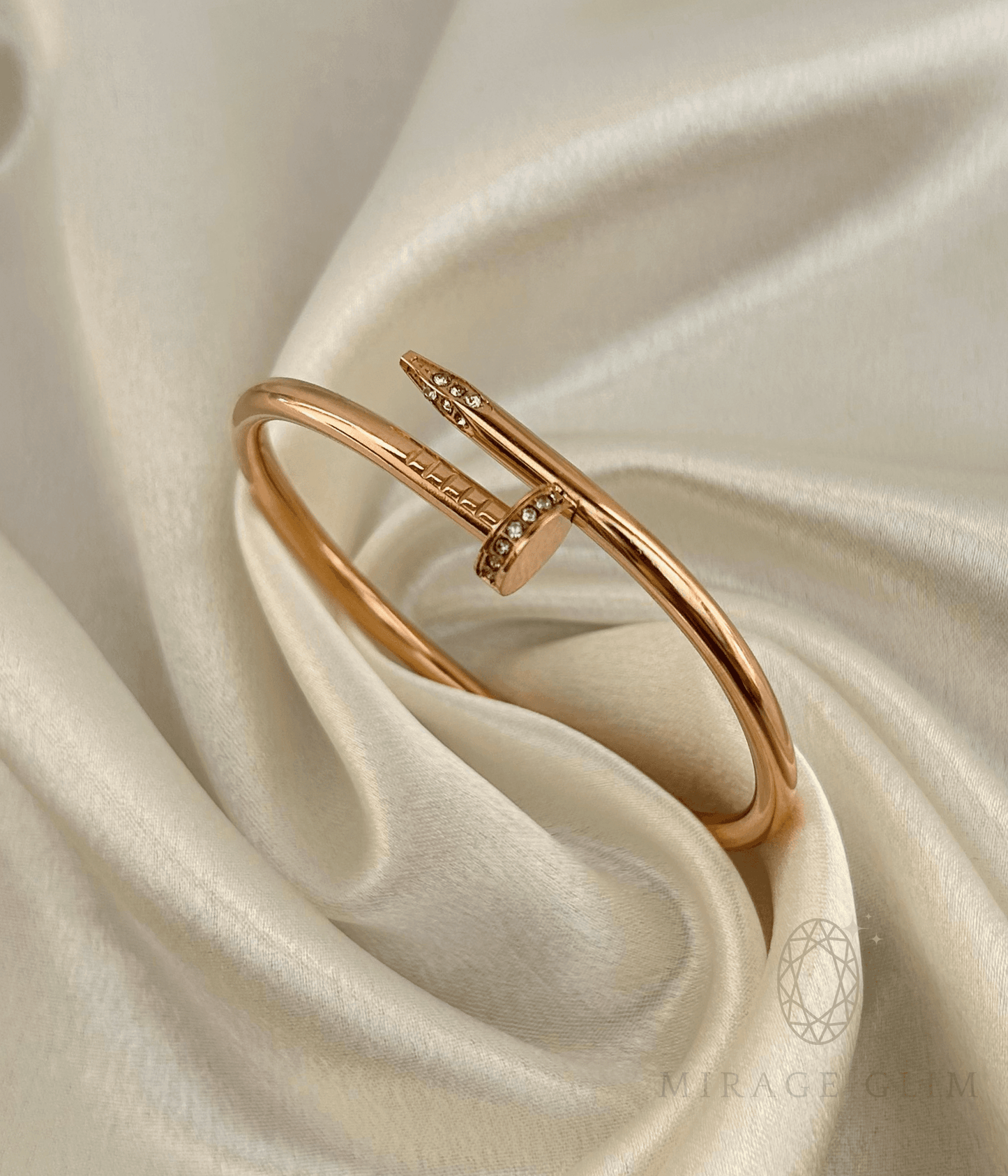 nail cuff bracelet resting on soft satin fabric