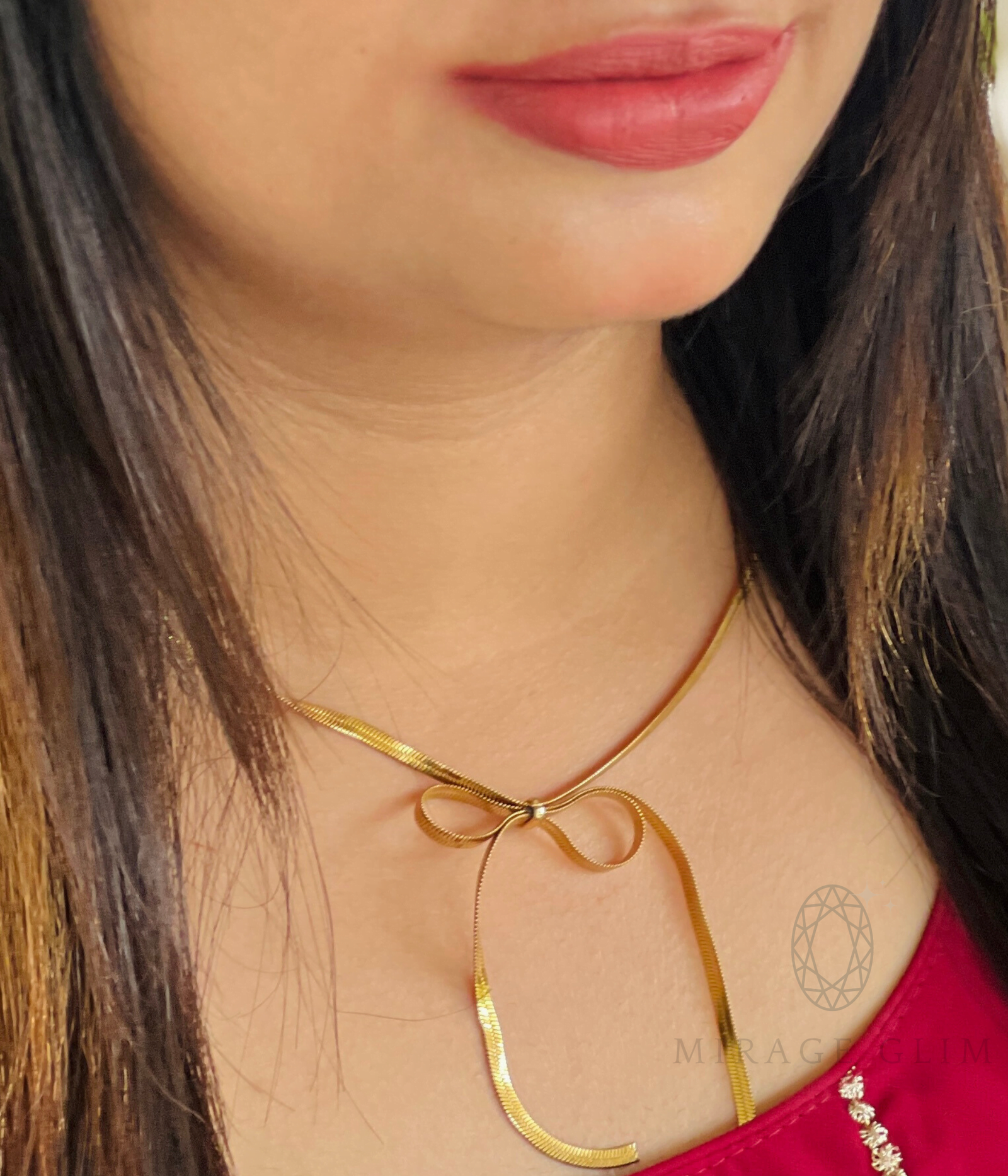 Gold bow tie necklace worn on neckline with elegant minimal design