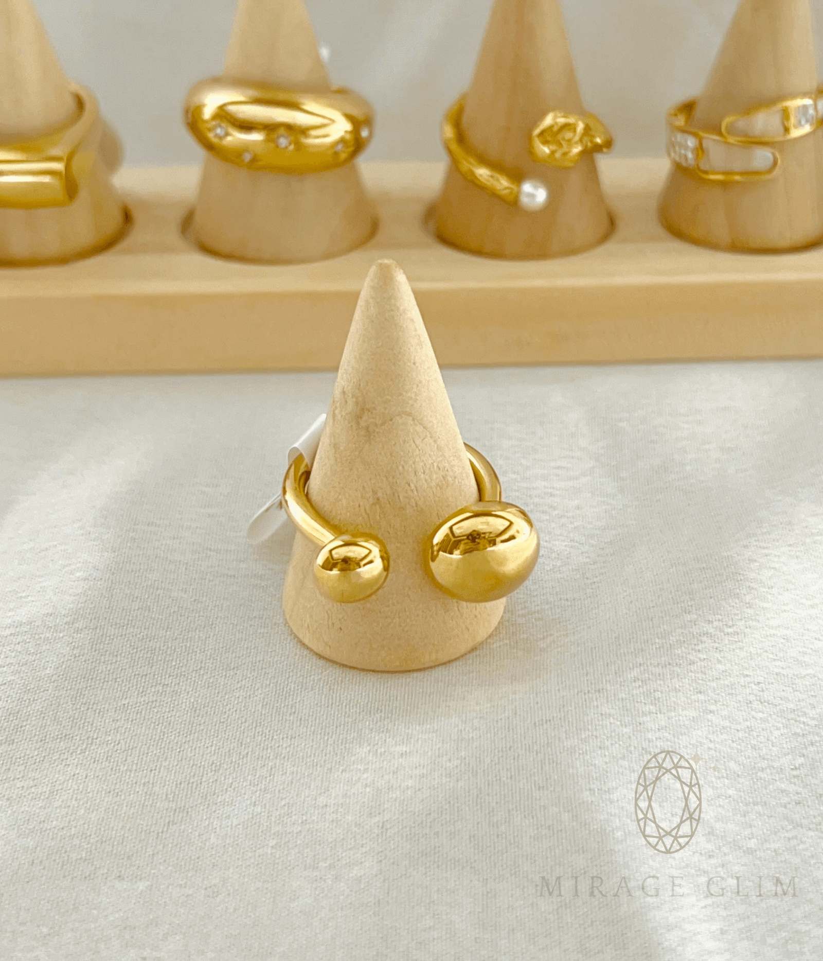 Open band ring with smooth golden globe ends in minimal design.