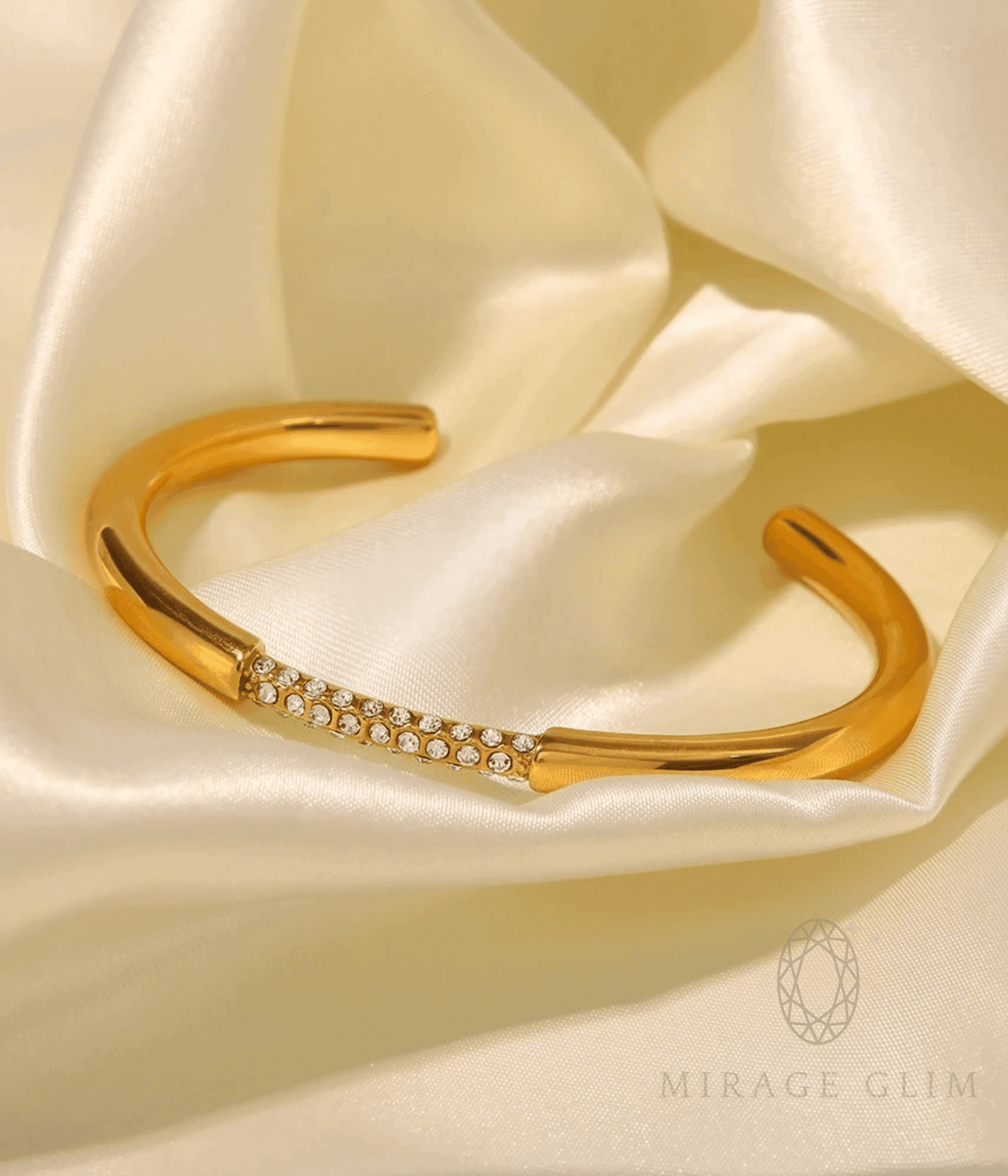Adjustable gold bangle with delicate crystal detailing on soft satin background