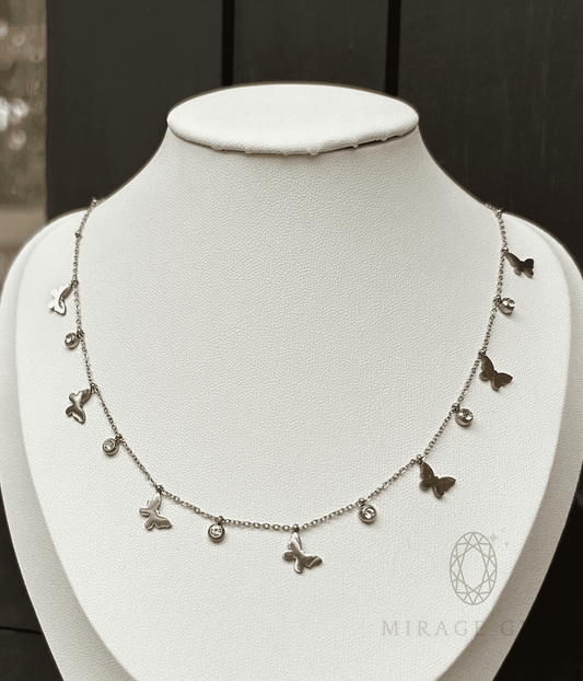 Silver butterfly necklace with delicate stones on a fine chain displayed on a white bust