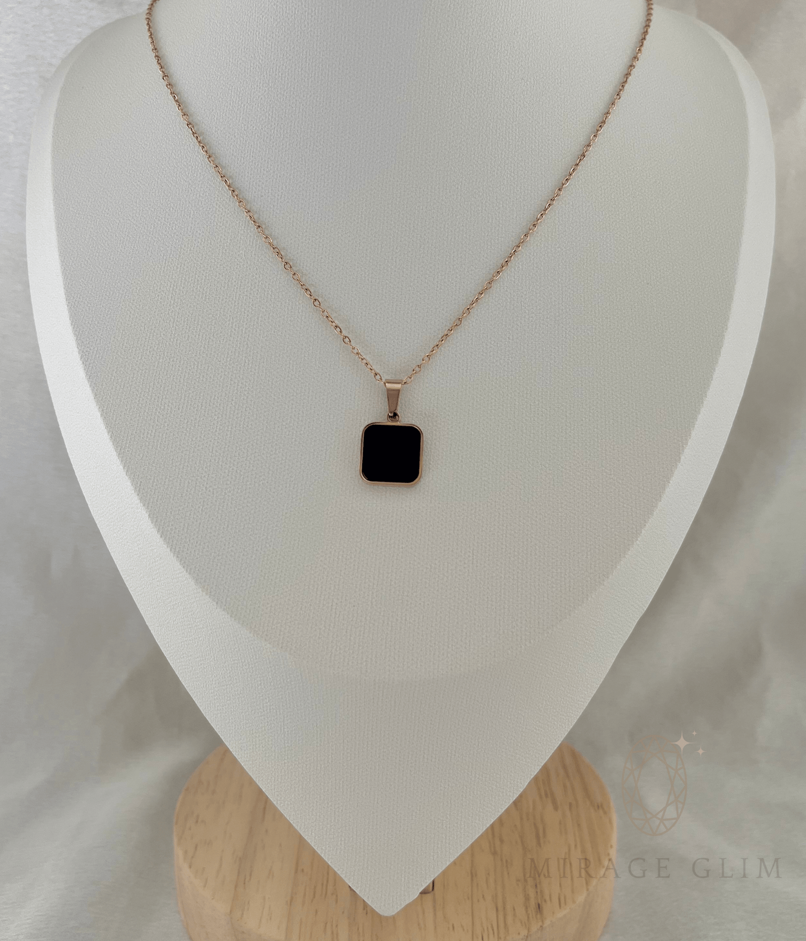 Necklace with a black square pendant on a white stand