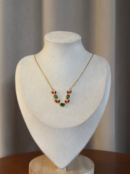Gold anti-tarnish tulip necklace featuring red tulip crystal petals and green gemstone accents on a delicate chain.