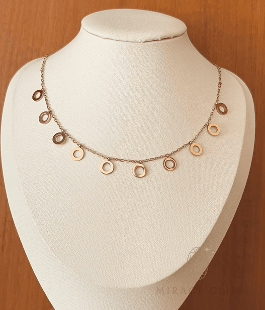Minimal necklace with small open charms spaced along a fine chain