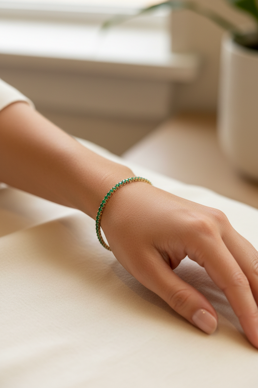 Hand wearing a green bracelet on a light surface