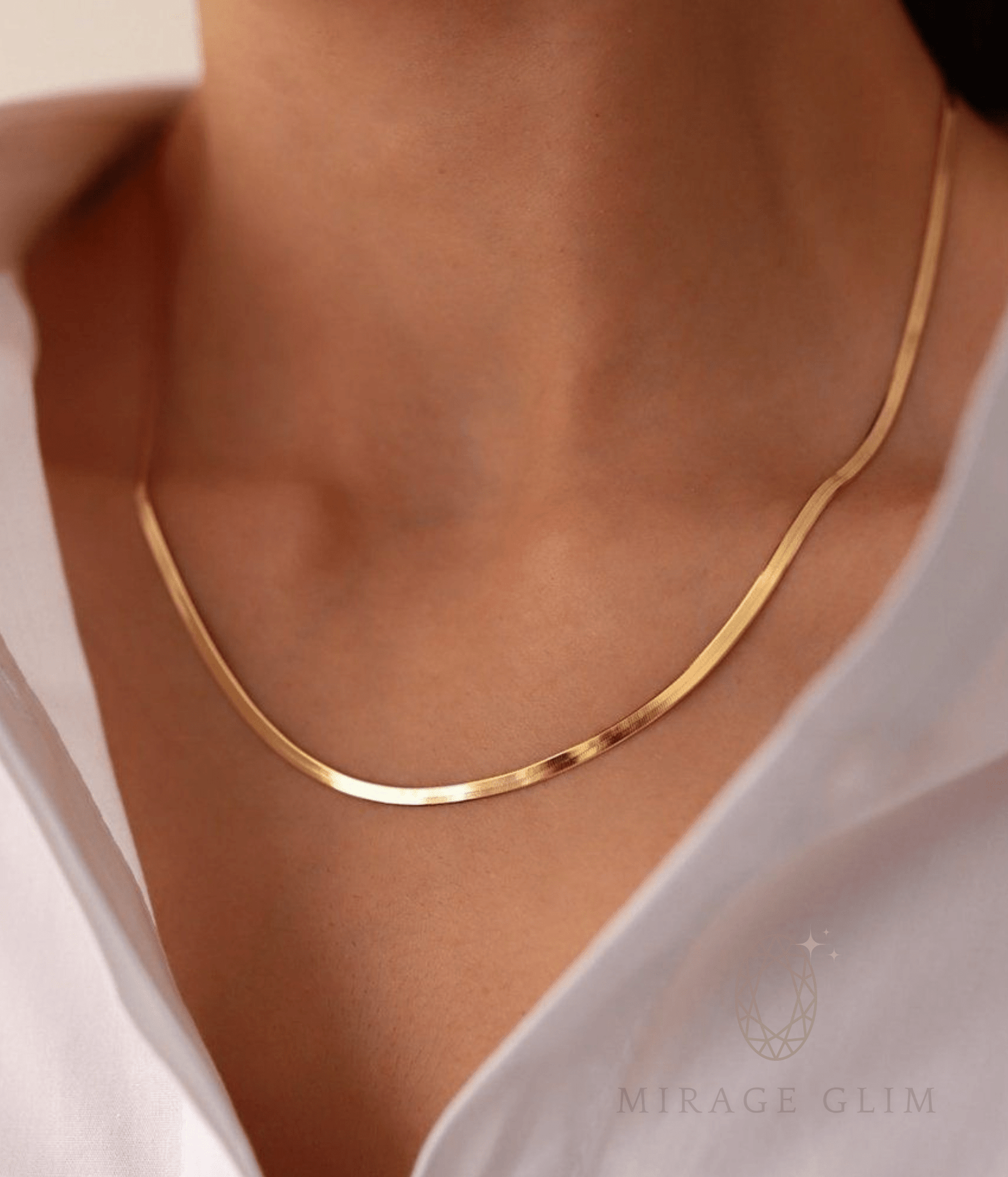 Minimal gold snake chain necklace worn on neckline