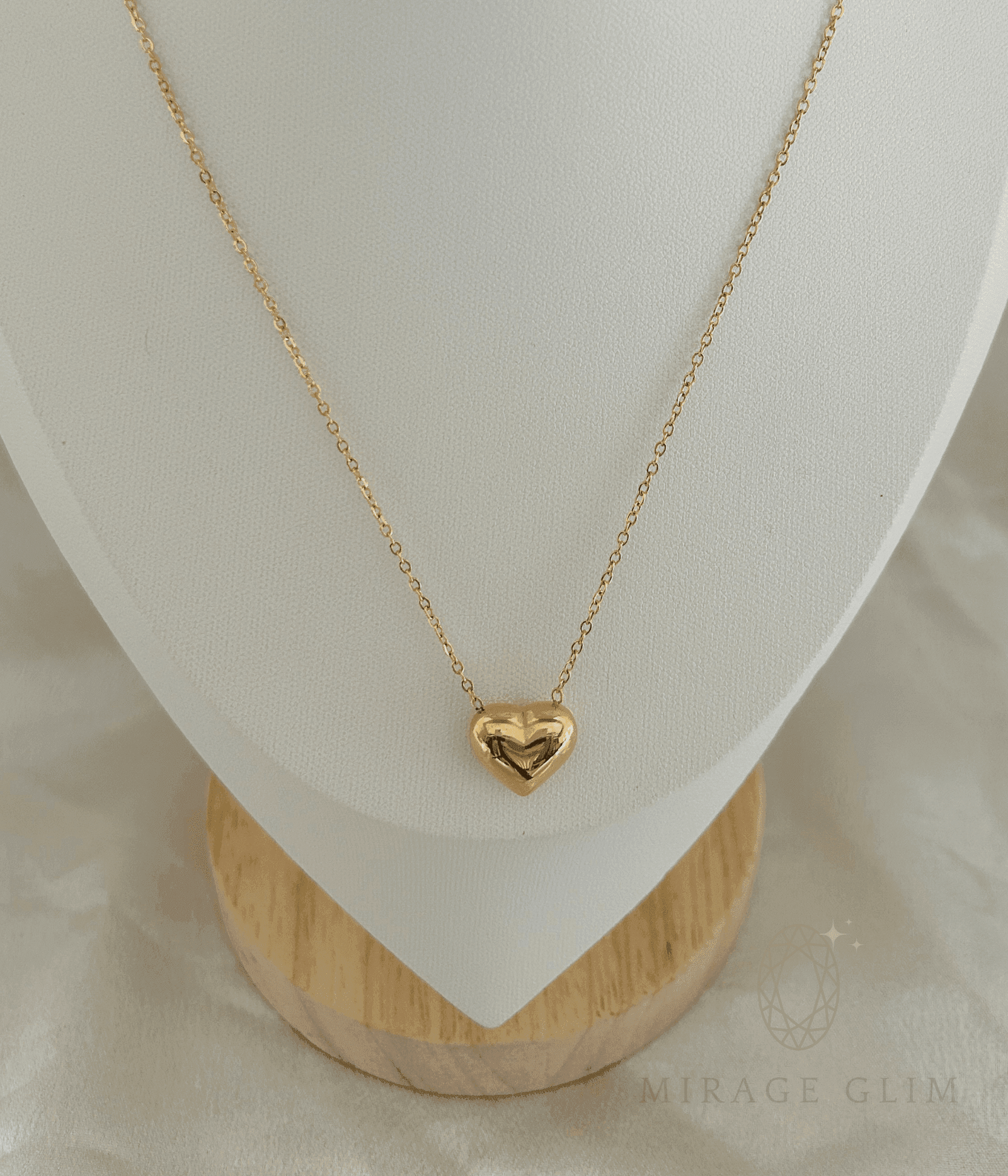 heart pendant necklace displayed on a minimal white jewelry stand