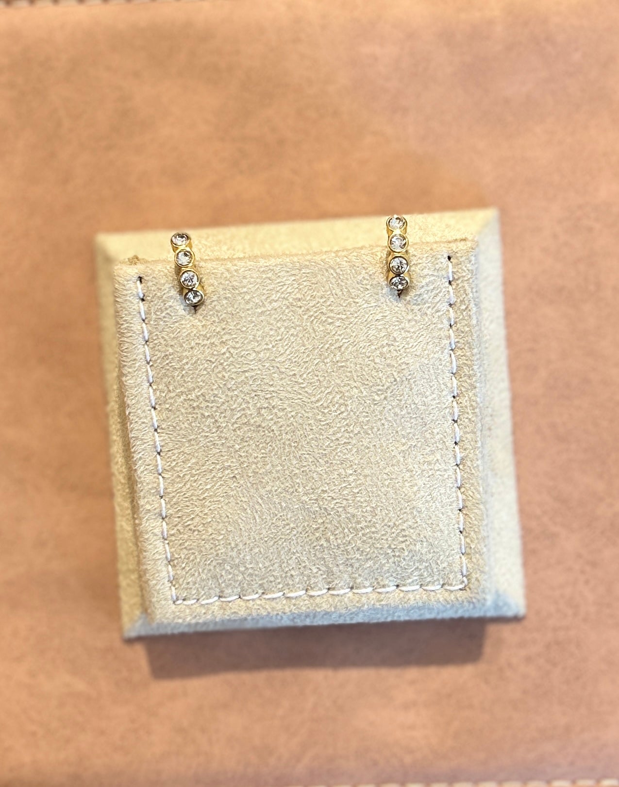 Necklace with small diamond-like stones on a beige fabric background
