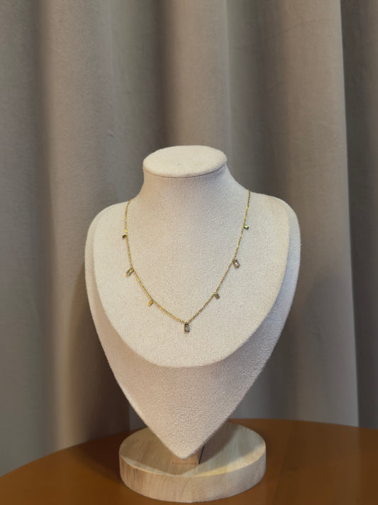 Elegant gold anti-tarnish charm necklace featuring delicate geometric crystal charms on a fine chain, designed for everyday elegance and layering.