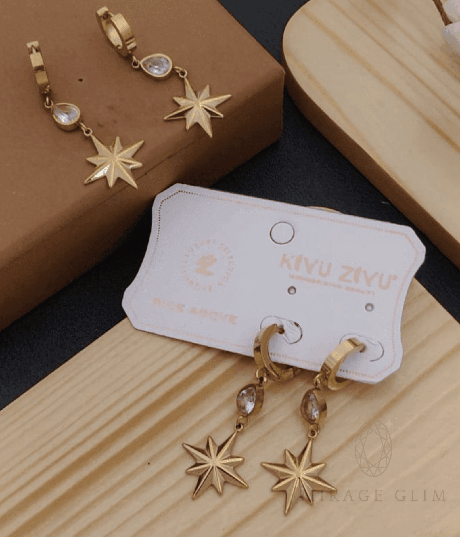 Elegant gold star drop earrings with crystal details on minimal display