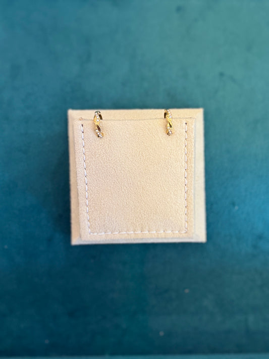 Small beige fabric patch with gold eyelets on a teal background